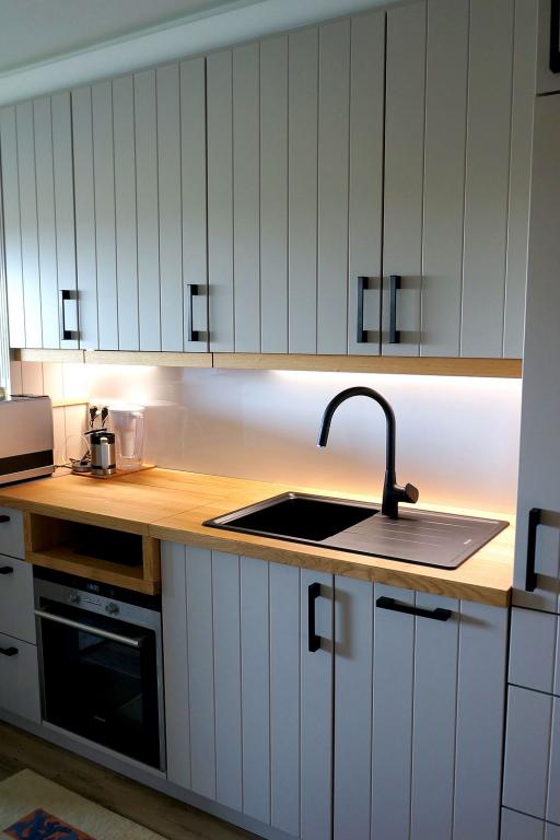 Pantry-Küche mit grauen Fronten und Naturholz-Arbeitsfläche