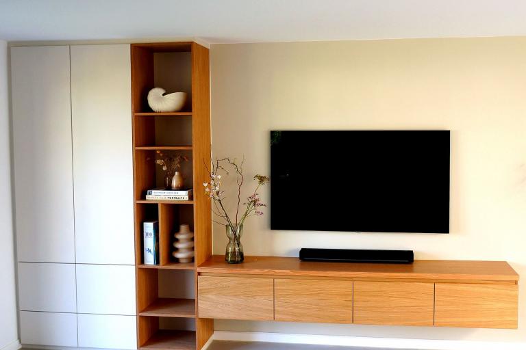 TV-Lowboard und Schrank mit weißen Türen und Fächern als Wohnwand