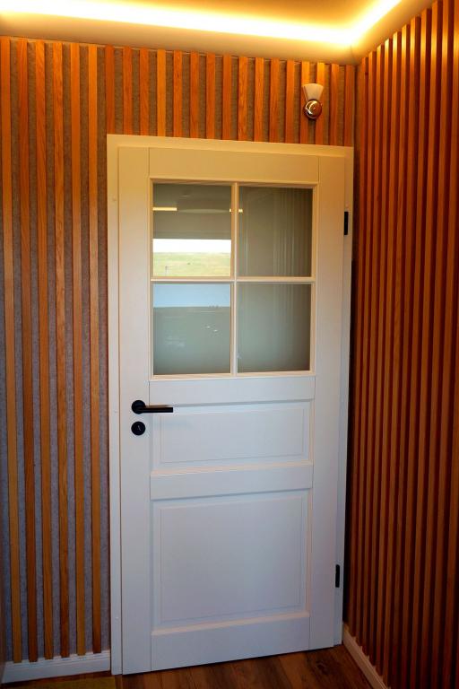 Weiß gelackte Landhaus-Tür mit Fenstern und Türschloss