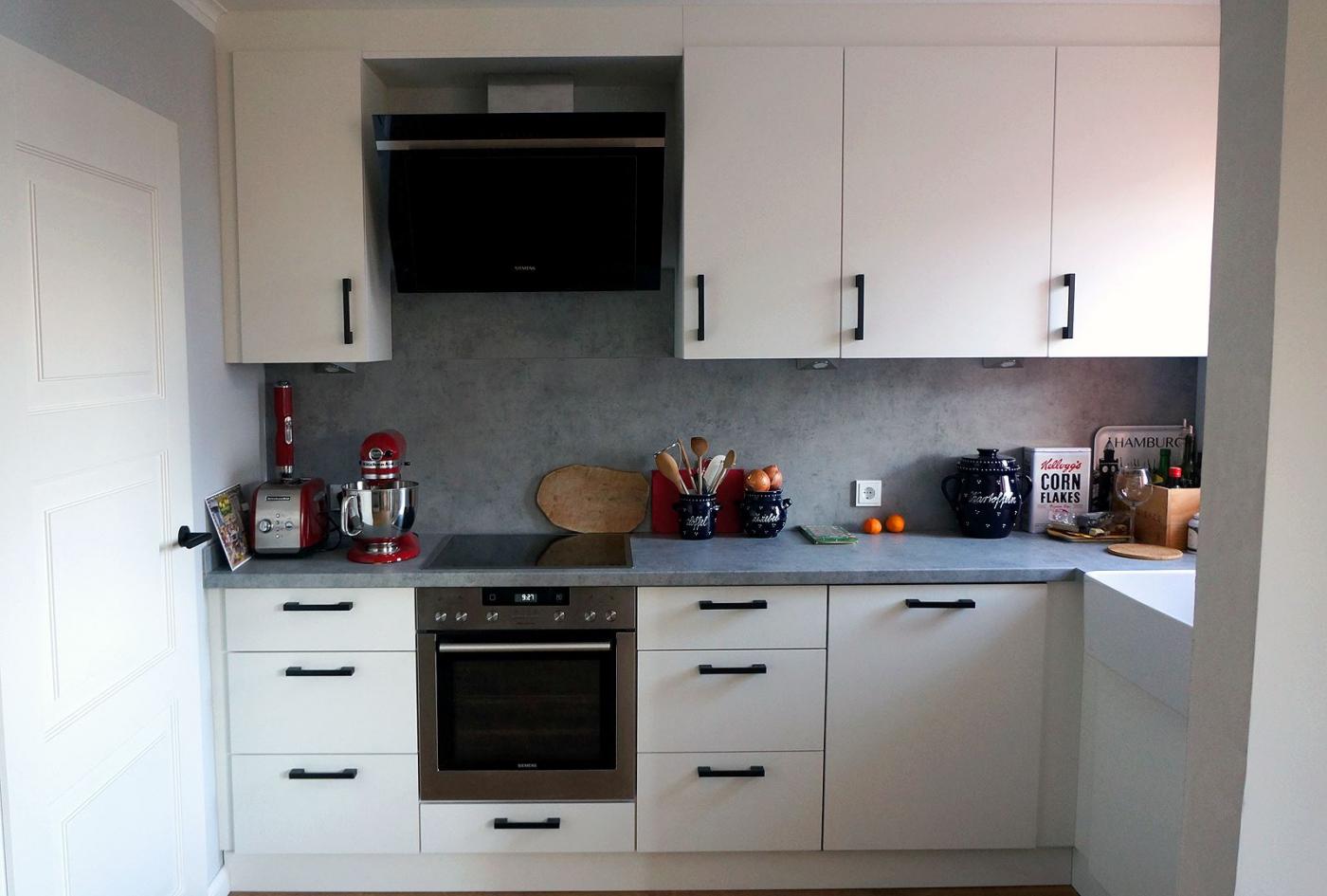 Küche mit weißen Fronten, Einbauherd und Dunstabzug