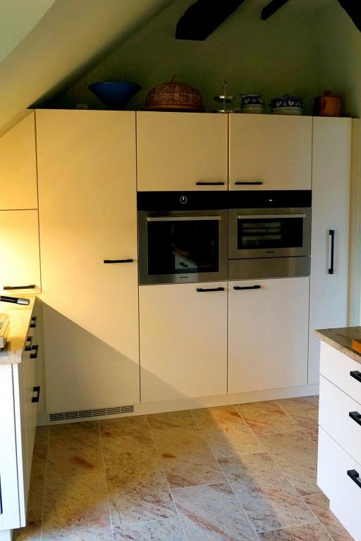 Einbauküche unter Dachschräge, weiße Fronten mit Einbaugeräten