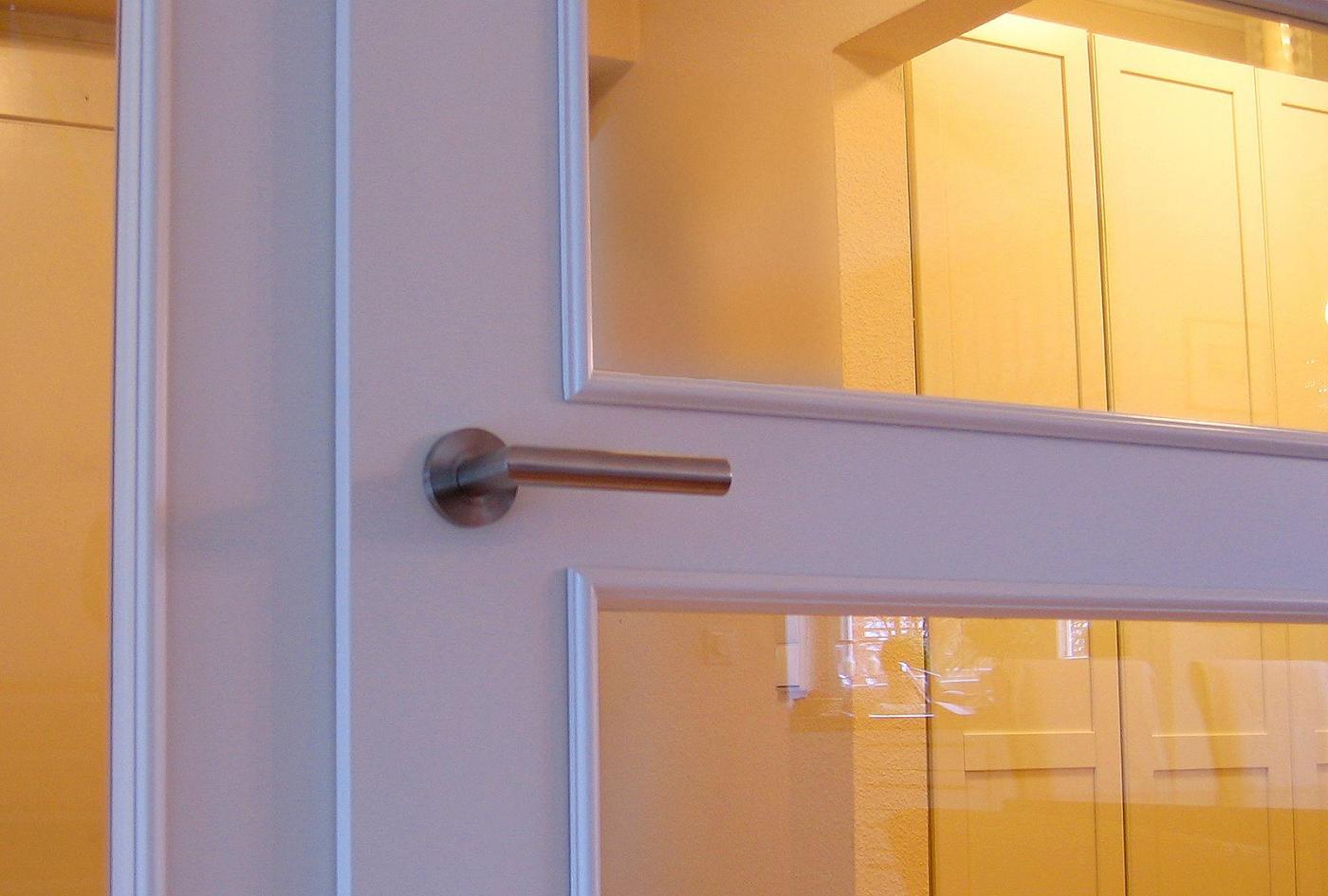 Weiß lackierte Holztür mit Glasfenstern und Metallgriff für Innenräume