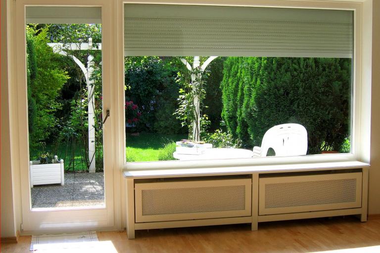 Weiß verkleideter Heizkörper unter der Fensterbank